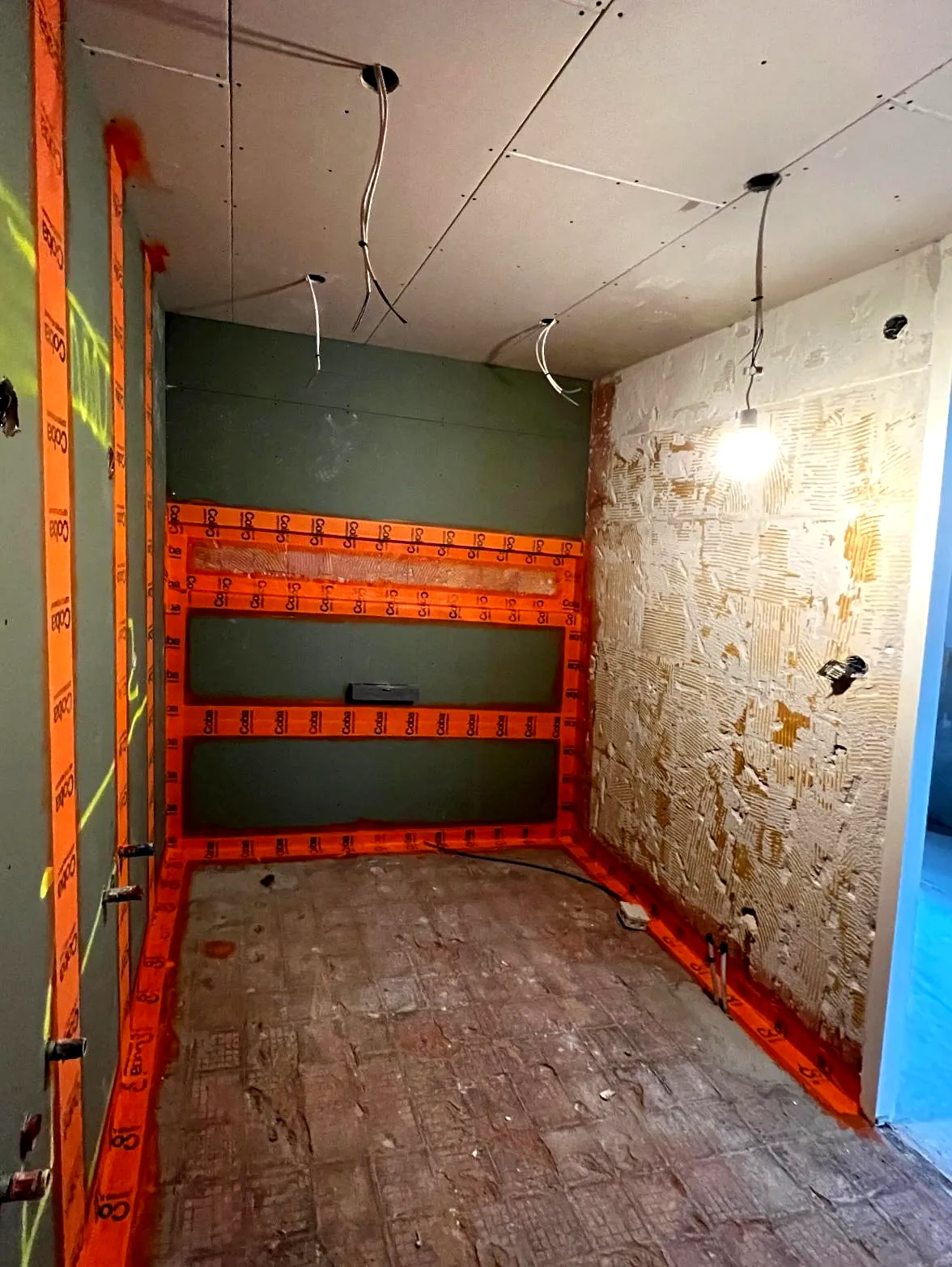 Badkamer in ruwbouwfase met leidingen, wandisolatie en voorbereid leidingwerk.
