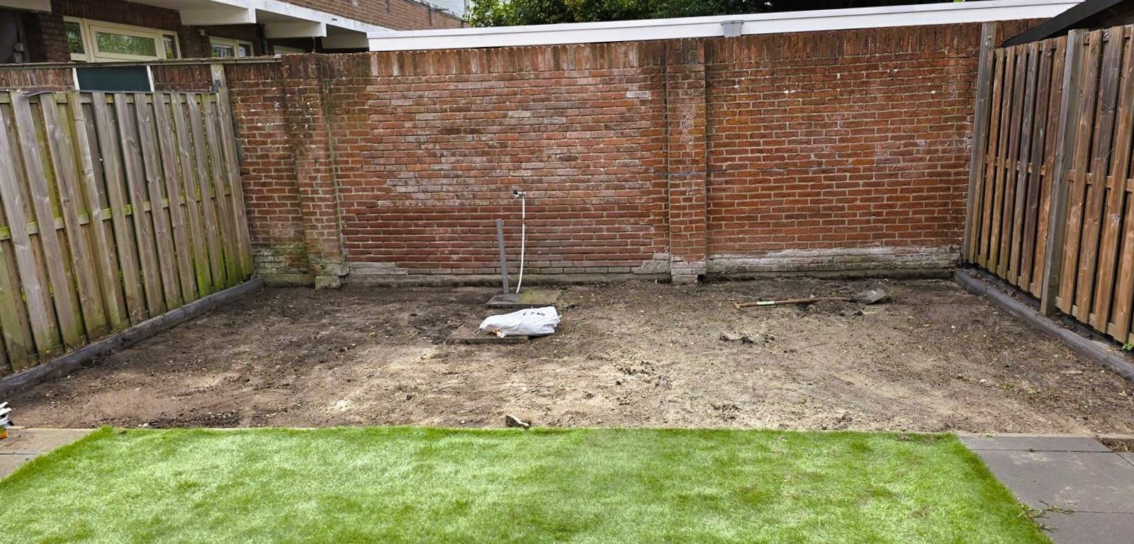 Voor situatie tuinhuis in Den Haag – lege tuin met fundering en voorbereidend grondwerk