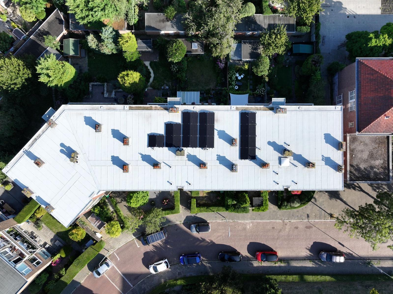 Luchtfoto van plat dak met nieuwe dakbedekking en zonnepanelen, aangelegd door dakdekker in Den Haag.